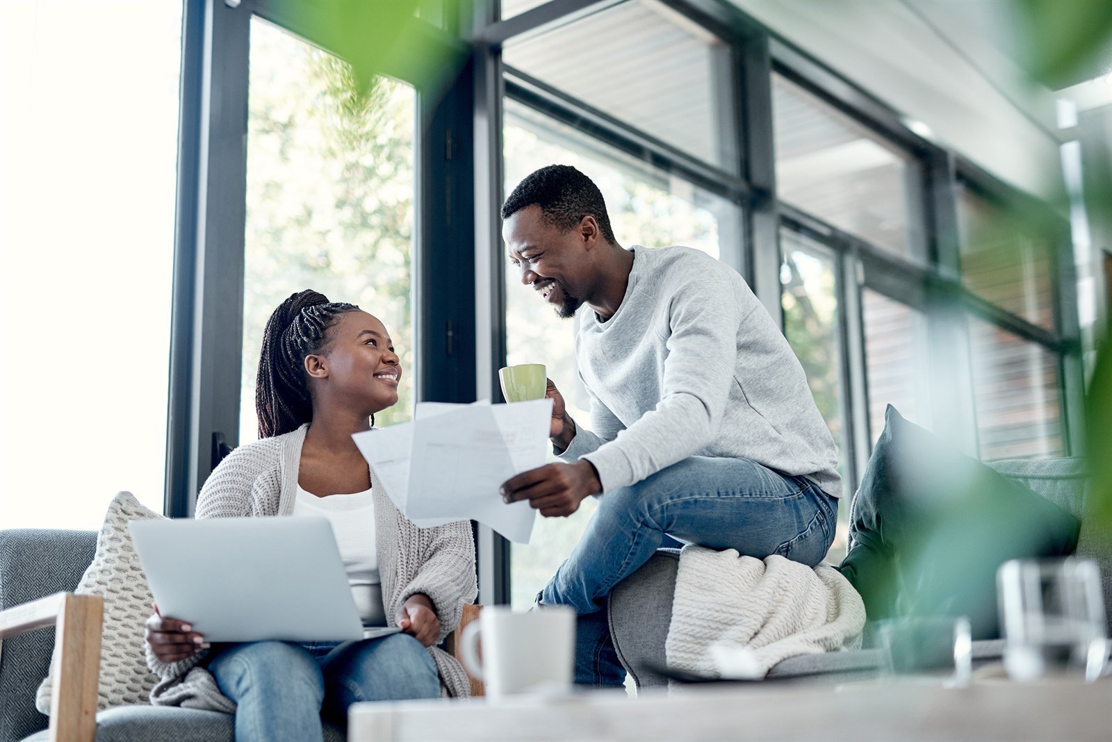 A couple at home going over bills and a laptop together while planning their monthly budget